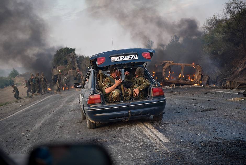Грузинские военные, чей БТР подбили, выбираются на гражданской машине из зоны боевых действий по дороге от Гори к Тбилиси, 11 августа
Фото: Cliff Volpe /Getty Images